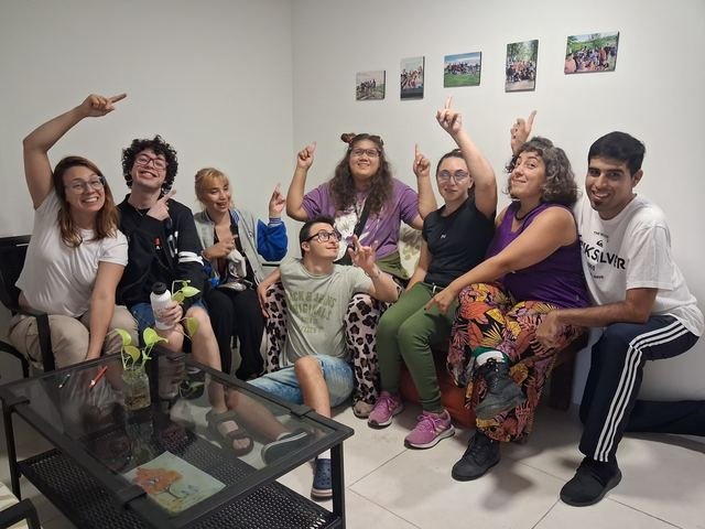 El grupo festejando con los brazos en alto en el espacio de Manijas