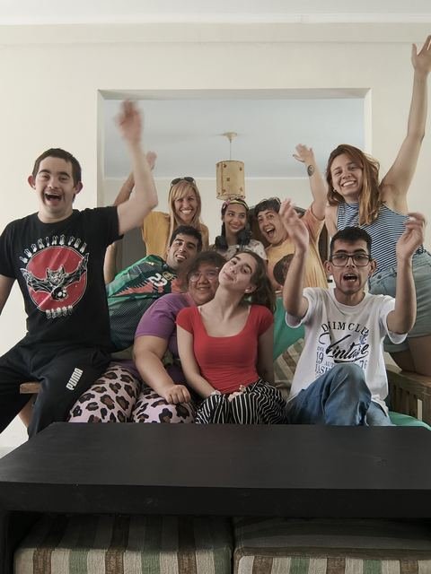 Participantes celebrando con los brazos en alto en la casa del viaje