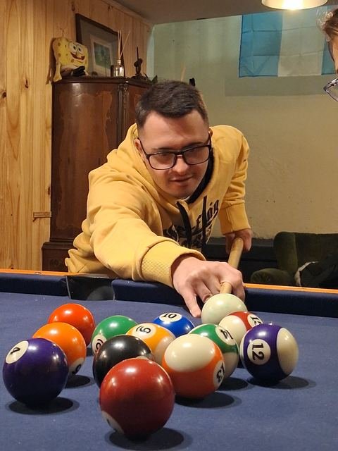 Un participante acomodando las bolas en la mesa de pool